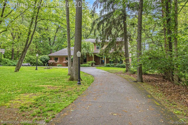 11187 Shadywood Dr, Brighton, MI 48114 - view of front of property with asphalt driveway, a front yard, and brick siding