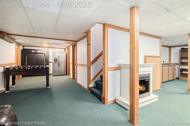 11187 Shadywood Dr, Brighton, MI 48114 - finished below grade area featuring stainless steel fridge with ice dispenser, a paneled ceiling, carpet, a warm lit fireplace, and stairs