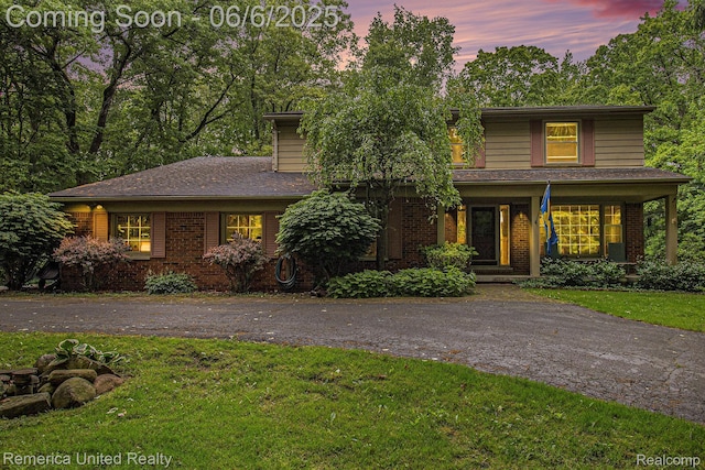 11187 Shadywood Dr, Brighton, MI 48114 - traditional home with a yard, brick siding, and covered porch