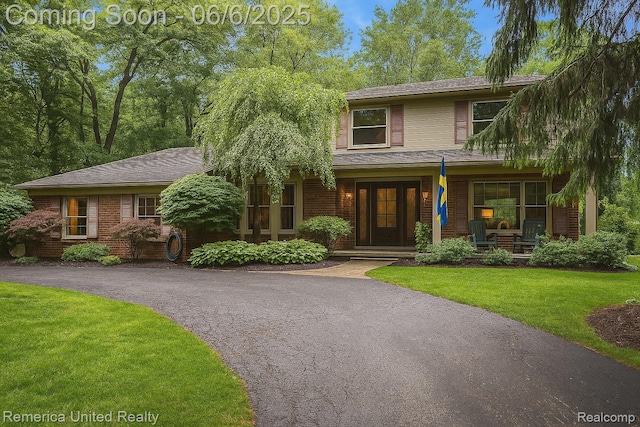 11187 Shadywood Dr, Brighton, MI 48114 - view of front of property with a front lawn, covered porch, and brick siding