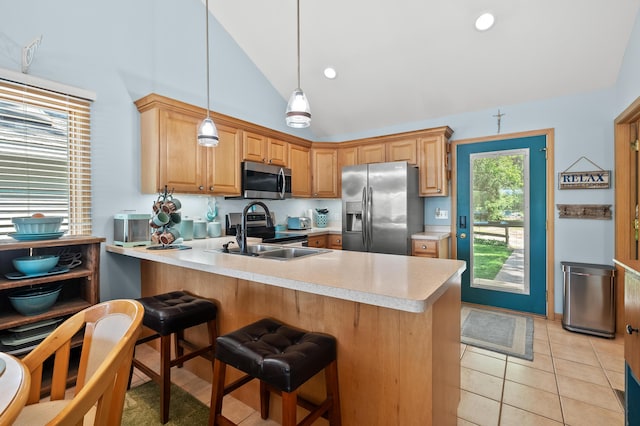 8843 Silver Lake Rd, Grand Junction, MI 49056 - kitchen with stainless steel appliances, light countertops, a peninsula, a breakfast bar, and decorative light fixtures