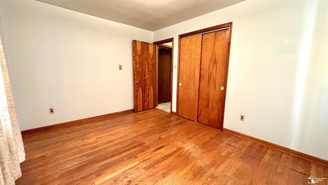 1220 N Raisinville Rd, Monroe, MI 48162 - unfurnished bedroom featuring light wood-style floors, baseboards, and a closet