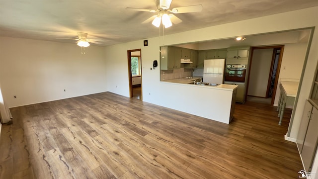 1220 N Raisinville Rd, Monroe, MI 48162 - kitchen featuring oven, a ceiling fan, freestanding refrigerator, a sink, and under cabinet range hood