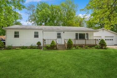 221 S Taylor St, New Buffalo, MI 49117 - ranch-style home featuring a front lawn, a garage, and driveway
