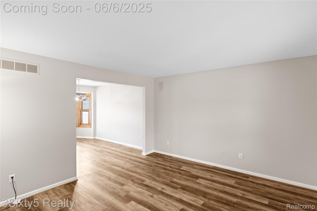 20605 Hickory St, Woodhaven, MI 48183 - spare room with baseboards, wood finished floors, and a chandelier