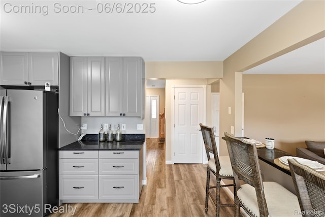 20605 Hickory St, Woodhaven, MI 48183 - kitchen with freestanding refrigerator, light wood-style flooring, and dark countertops