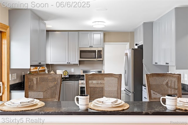 20605 Hickory St, Woodhaven, MI 48183 - kitchen featuring stainless steel appliances, dark stone countertops, and gray cabinets