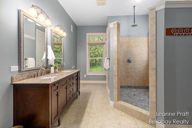 1020 E Woodlawn Ave, Hastings, MI 49058 - bathroom with tiled shower, double vanity, tile patterned floors, and baseboards