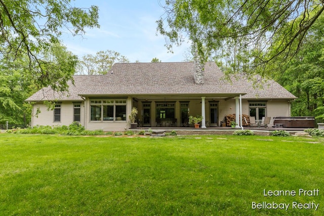 1020 E Woodlawn Ave, Hastings, MI 49058 - back of property with a hot tub, a lawn, and roof with shingles