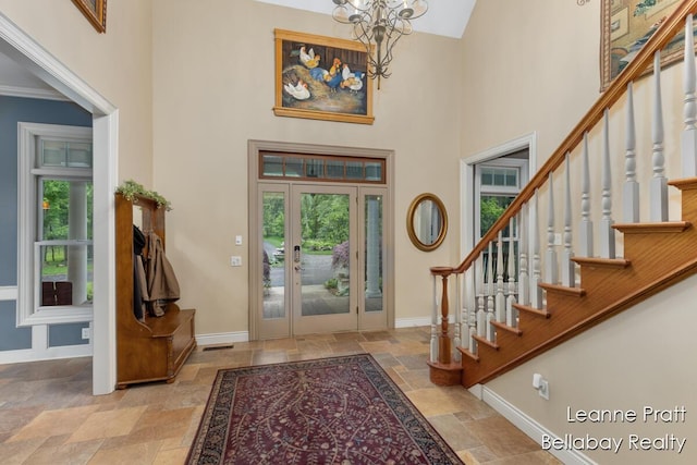 1020 E Woodlawn Ave, Hastings, MI 49058 - foyer entrance featuring stone tile floors, plenty of natural light, baseboards, a high ceiling, and a chandelier