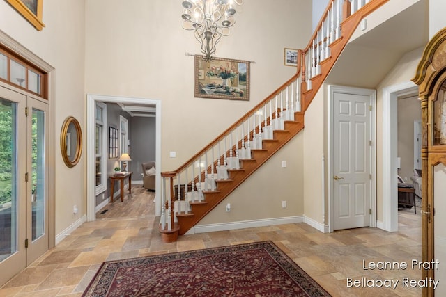 1020 E Woodlawn Ave, Hastings, MI 49058 - entrance foyer featuring stone tile flooring, a high ceiling, stairway, baseboards, and a chandelier