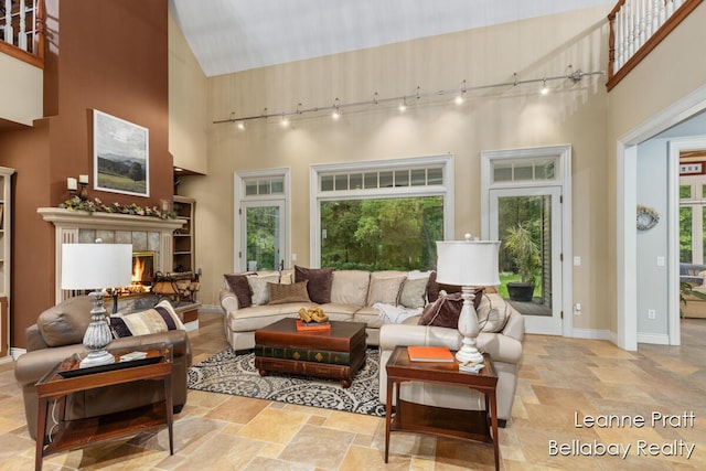 1020 E Woodlawn Ave, Hastings, MI 49058 - living area featuring a towering ceiling, plenty of natural light, a tiled fireplace, track lighting, and stone finish flooring