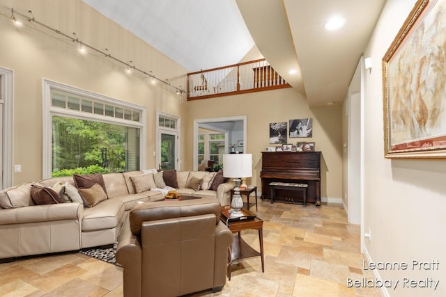 1020 E Woodlawn Ave, Hastings, MI 49058 - living area with track lighting, light stone finish floors, baseboards, a towering ceiling, and recessed lighting