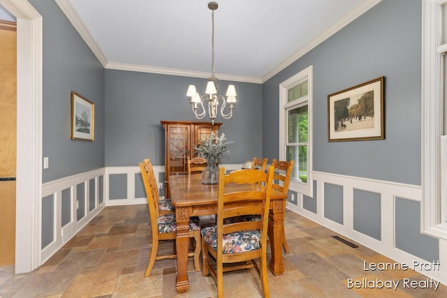 1020 E Woodlawn Ave, Hastings, MI 49058 - dining area with stone finish floors, a chandelier, and crown molding