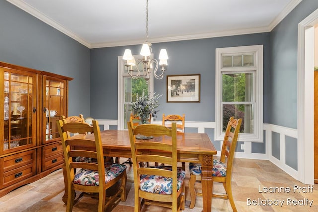 1020 E Woodlawn Ave, Hastings, MI 49058 - dining room with light stone finish flooring, a chandelier, crown molding, and wainscoting