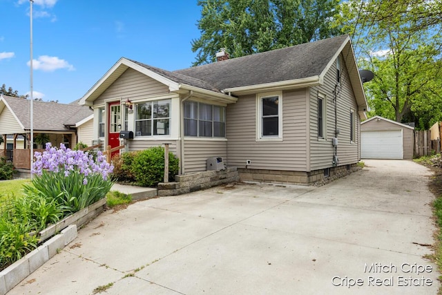 772 26th St SW, Wyoming, MI 49509 - bungalow-style house featuring a garage, an outdoor structure, a chimney, and a shingled roof