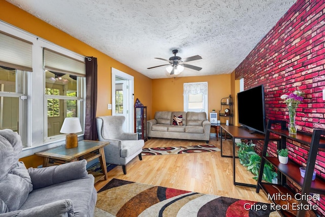 772 26th St SW, Wyoming, MI 49509 - living area featuring a ceiling fan, wood finished floors, a textured ceiling, and brick wall