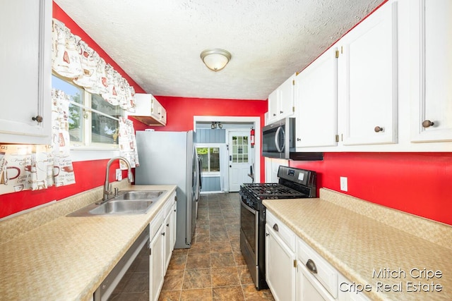 772 26th St SW, Wyoming, MI 49509 - kitchen with stainless steel appliances, a sink, white cabinets, light countertops, and healthy amount of natural light