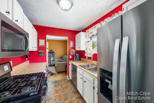 772 26th St SW, Wyoming, MI 49509 - kitchen featuring stainless steel appliances, a sink, white cabinets, light countertops, and a textured ceiling