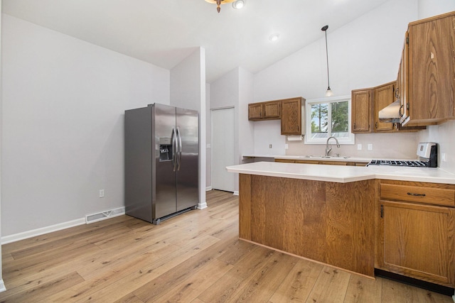 4273 20th St, Dorr, MI 49323 - kitchen featuring stainless steel fridge with ice dispenser, under cabinet range hood, a peninsula, brown cabinets, and a sink