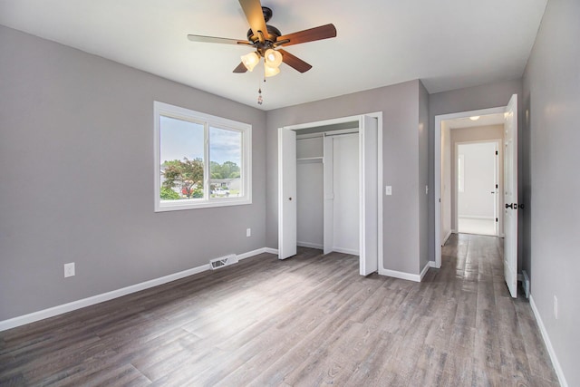 4273 20th St, Dorr, MI 49323 - unfurnished bedroom featuring baseboards, wood finished floors, a closet, and ceiling fan