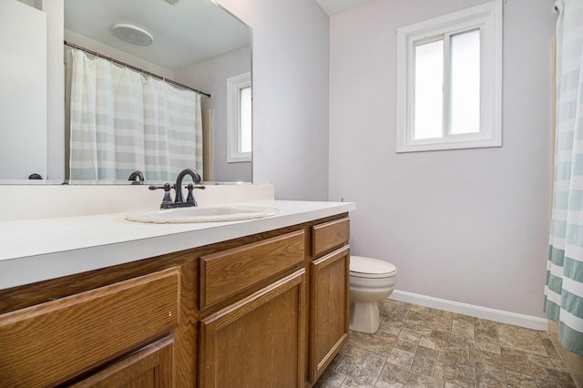 4273 20th St, Dorr, MI 49323 - bathroom with vanity, toilet, stone finish floors, and baseboards