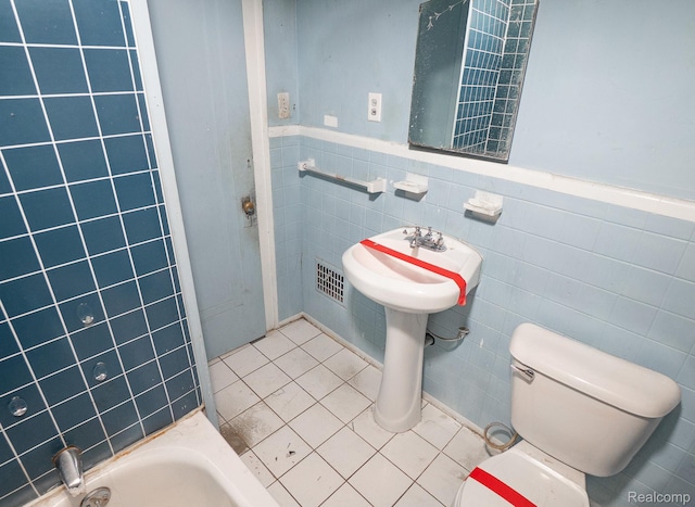 15859 Cloverlawn St, Detroit, MI 48238 - bathroom with tile walls, a wainscoted wall, tile patterned floors, and a bath