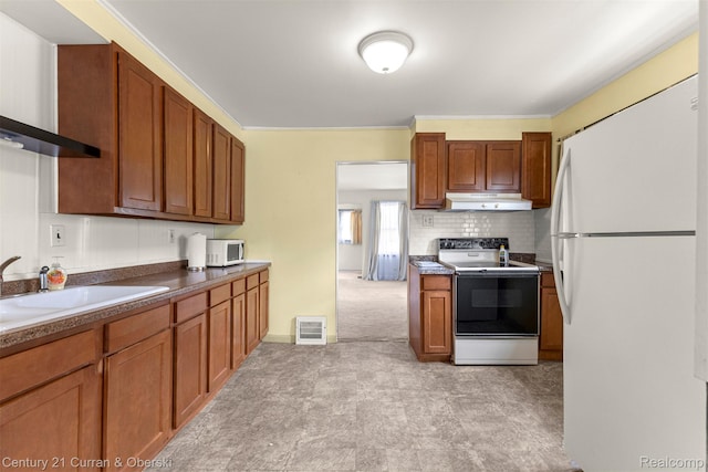 2143 Boldt St, Dearborn, MI 48124 - kitchen with white appliances, under cabinet range hood, wall chimney range hood, a sink, and brown cabinets