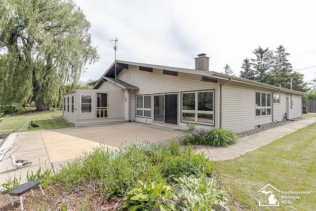 6337 Raymar St, Erie, MI 48133 - rear view of property featuring a chimney, a lawn, and a patio area