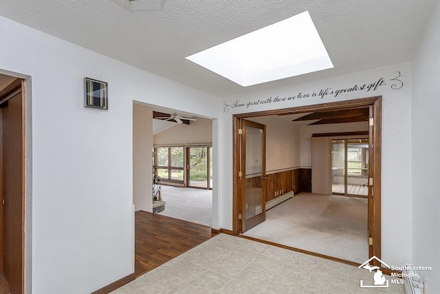 6337 Raymar St, Erie, MI 48133 - corridor with a skylight, carpet flooring, a textured ceiling, a wainscoted wall, and baseboard heating