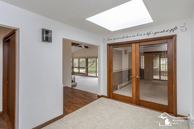 6337 Raymar St, Erie, MI 48133 - unfurnished room with a skylight, baseboard heating, french doors, baseboards, and vaulted ceiling