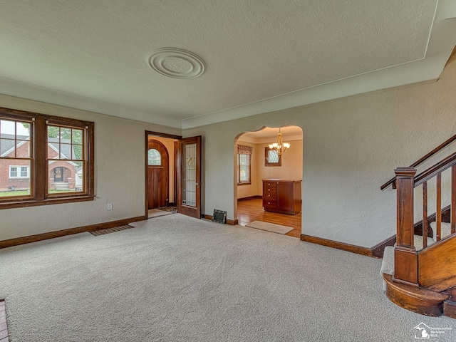 27145 James Ave, Flat Rock, MI 48134 - carpeted foyer with arched walkways, a textured ceiling, baseboards, a chandelier, and a textured wall