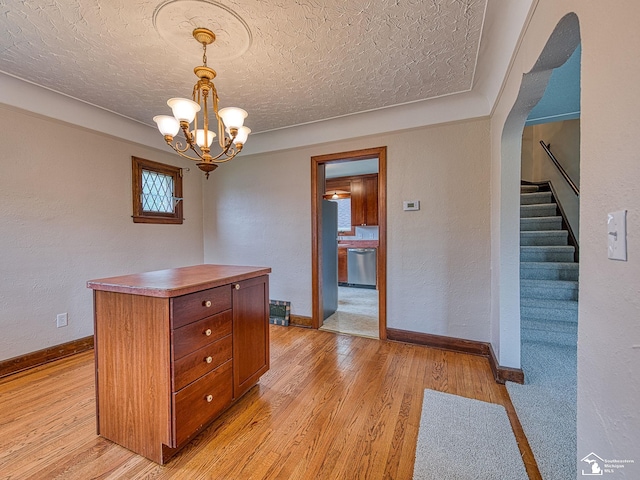 27145 James Ave, Flat Rock, MI 48134 - unfurnished dining area with light wood-type flooring, a chandelier, a textured ceiling, baseboards, and stairway