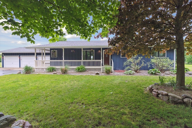 303 E Xy Ave, Vicksburg, MI 49097 - view of front of home featuring board and batten siding, a garage, an outdoor structure, and a front lawn