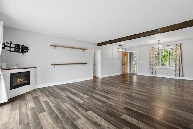 303 E Xy Ave, Vicksburg, MI 49097 - unfurnished living room featuring wood finished floors, a glass covered fireplace, a chandelier, beam ceiling, and baseboards