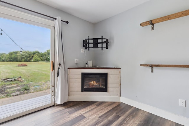 303 E Xy Ave, Vicksburg, MI 49097 - unfurnished living room featuring a glass covered fireplace, dark wood-style floors, and baseboards