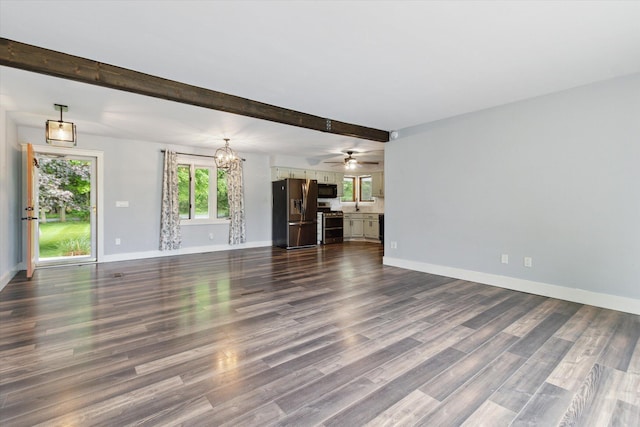 303 E Xy Ave, Vicksburg, MI 49097 - unfurnished living room featuring a chandelier, baseboards, dark wood-style floors, beamed ceiling, and a sink