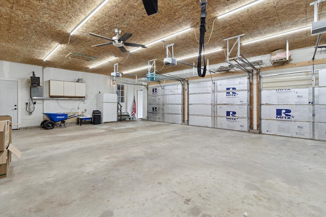303 E Xy Ave, Vicksburg, MI 49097 - garage featuring a garage door opener and freestanding refrigerator
