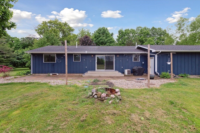 303 E Xy Ave, Vicksburg, MI 49097 - back of property with board and batten siding, a lawn, a patio, and a fire pit