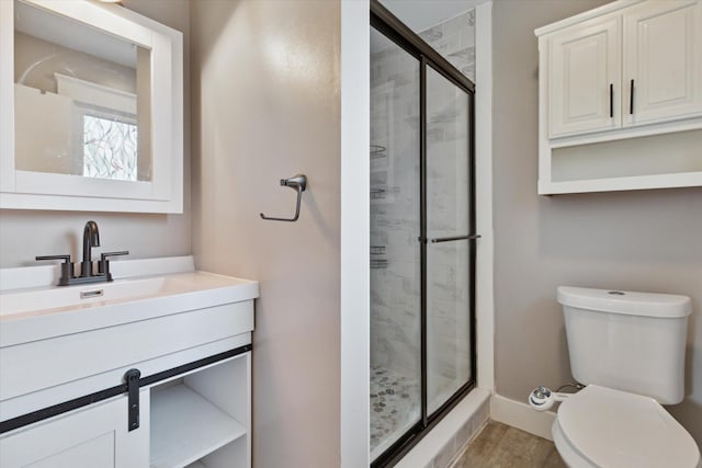 303 E Xy Ave, Vicksburg, MI 49097 - full bathroom featuring a shower stall, vanity, toilet, wood finished floors, and baseboards