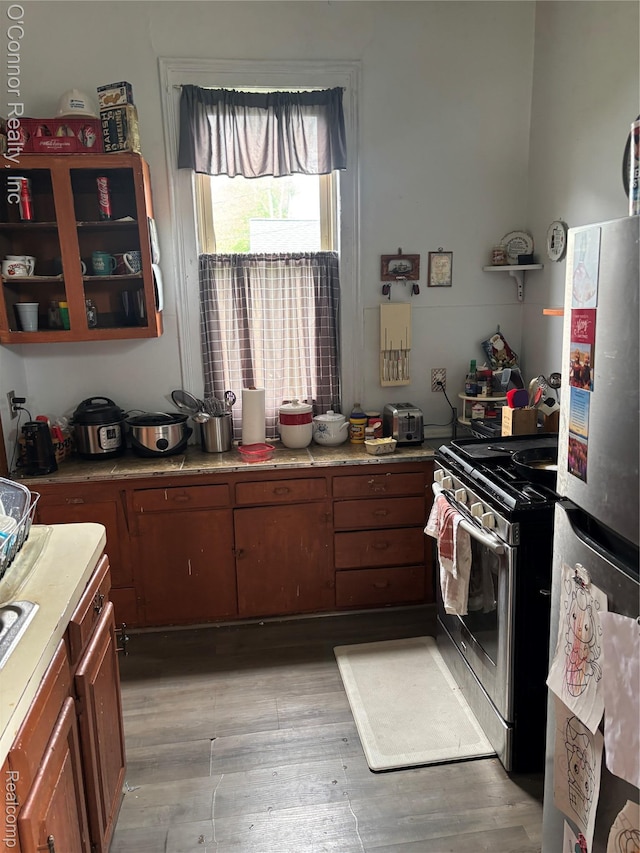 236 S Elizabeth St, Marine City, MI 48039 - kitchen featuring stainless steel appliances, light wood-style floors, light countertops, and brown cabinetry