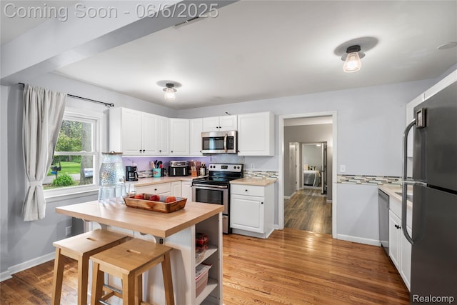 6226 Rowley Blvd, Waterford, MI 48329 - kitchen with stainless steel appliances, white cabinets, butcher block counters, and baseboards
