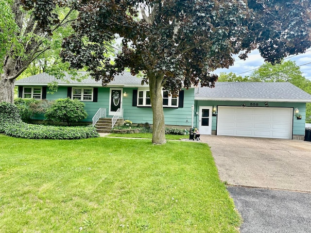 558 Terry St, Muskegon, MI 49442 - view of front of property with asphalt driveway, a garage, a front lawn, and a shingled roof