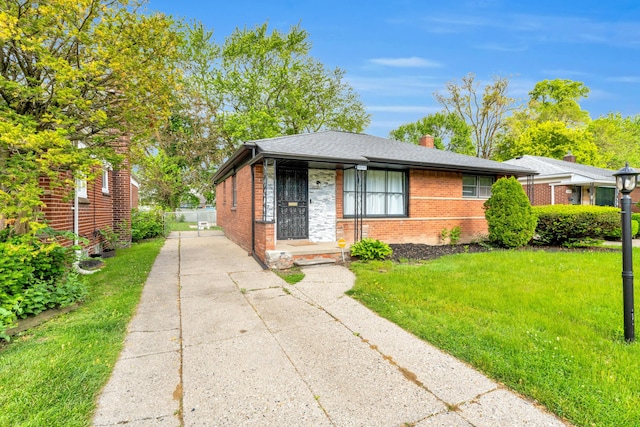 20241 Braile St, Detroit, MI 48219 - view of front of house featuring brick siding, concrete driveway, a front yard, and a shingled roof