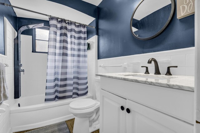 20241 Braile St, Detroit, MI 48219 - bathroom with vanity, toilet, shower / bath combo, tile walls, and a wainscoted wall