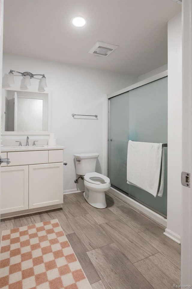 1755 Country View Dr, Okemos, MI 48864 - full bathroom with vanity, a shower stall, wood finished floors, toilet, and recessed lighting