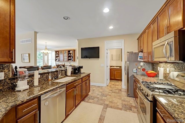 59649 Mallory Ln, South Lyon, MI 48178 - kitchen with appliances with stainless steel finishes, a sink, tasteful backsplash, a chandelier, and recessed lighting