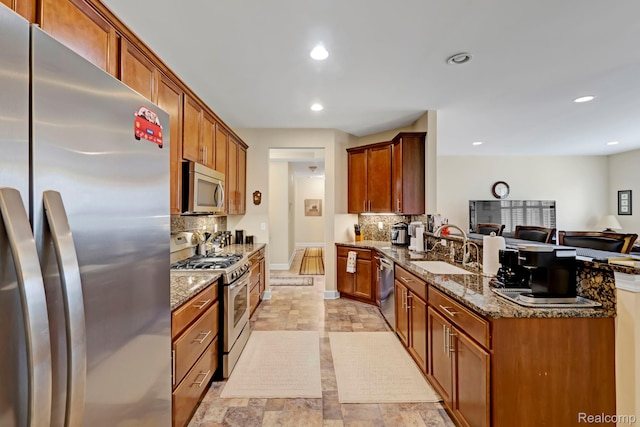 59649 Mallory Ln, South Lyon, MI 48178 - kitchen featuring stainless steel appliances, a peninsula, tasteful backsplash, a sink, and recessed lighting