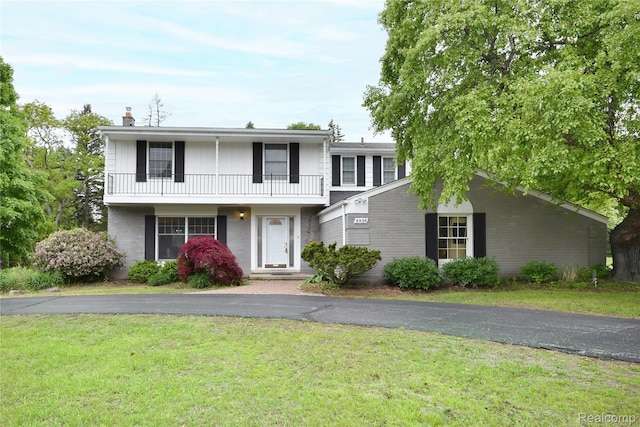 6835 Limerick Ln, Troy, MI 48098 - view of front of home featuring a balcony, a front yard, a chimney, and brick siding