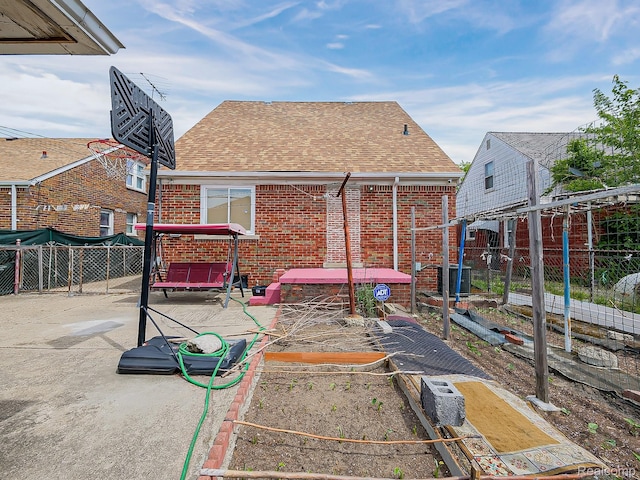 3878 Charles St, Hamtramck, MI 48212 - rear view of house with brick siding, roof with shingles, and a vegetable garden
